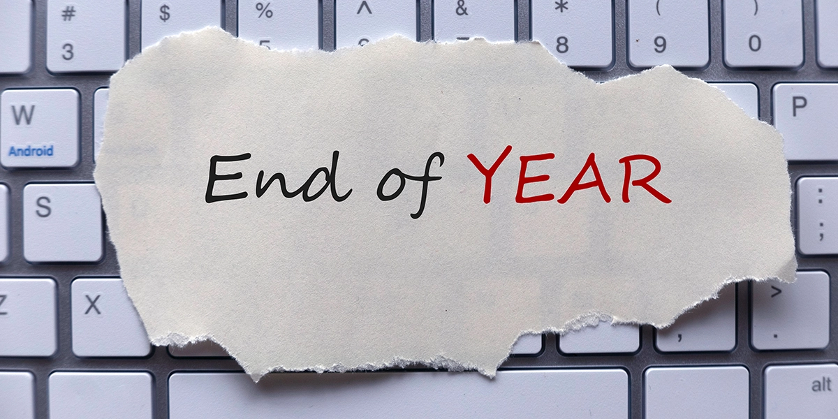 A torn paper with 'End of Year' written on it placed on a keyboard, representing UK Year-End Tax Summaries review.